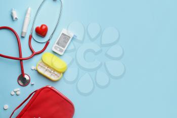 Glucometer with pills, stethoscope, lancet pen and heart on color background. Diabetes concept�