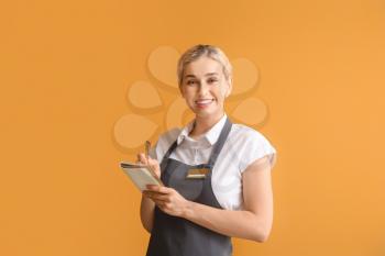 Young female waiter on color background�