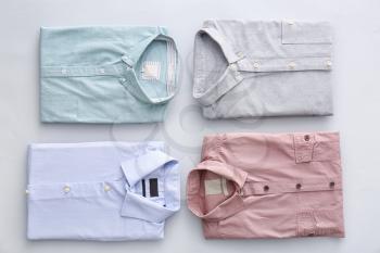 Folded male shirts on light background�