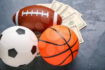 Money and balls on dark background. Concept of sports bet�