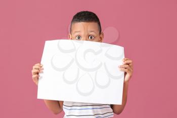 Little African-American boy with blank poster on color background�