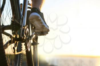 Male cyclist riding bicycle outdoors, closeup�