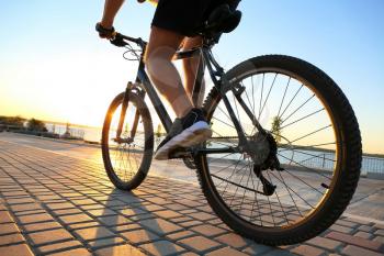 Male cyclist riding bicycle outdoors, closeup�