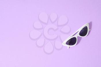 Stylish sunglasses on color background�