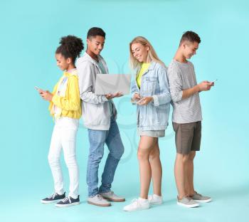 Teenagers with different devices on color background�