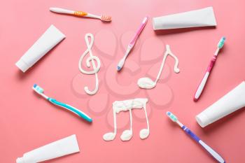 Drawn music notes and tooth brushes with paste on color background�