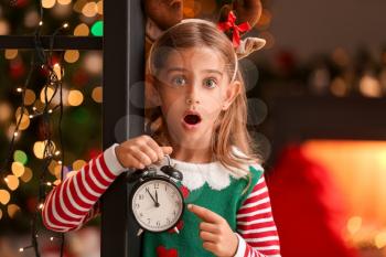 Surprised little elf with alarm clock at home on Christmas eve�