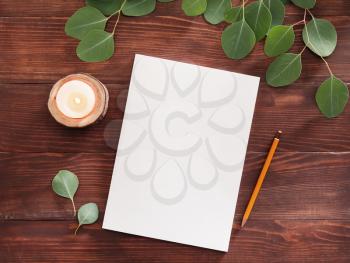 Blank magazine, candle and pencil on wooden background�