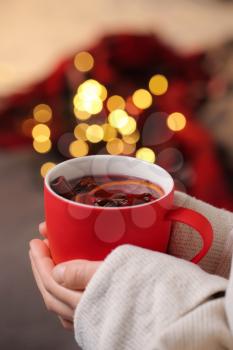 Woman drinking tasty mulled wine at home on Christmas eve�
