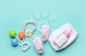 Bottle of milk for baby and accessories on color background�