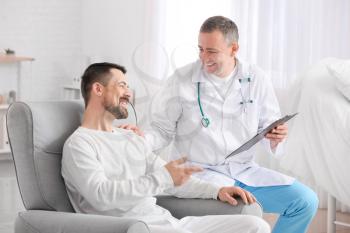 Doctor and man undergoing course of chemotherapy in clinic. Prostate cancer awareness concept�
