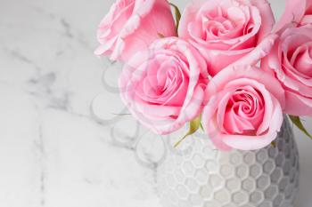 Beautiful pink roses in vase on light background�