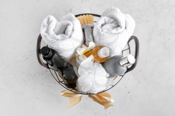 Gift basket with bathroom supplies on light background�