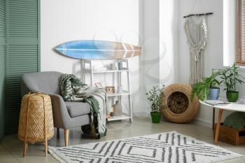 Interior of modern stylish room with surfboard and armchair�