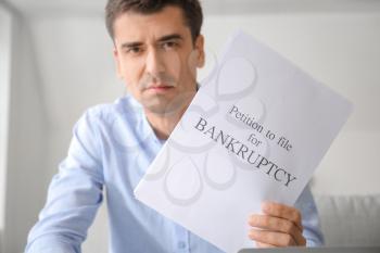 Stressed man with petition to file for bankruptcy at home�