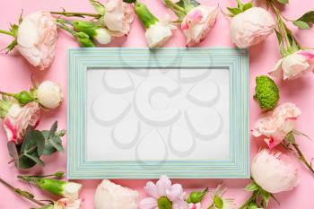 Beautiful flowers and blank frame on color background�