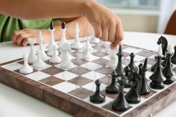 Cute African-American boy playing chess at home, closeup�