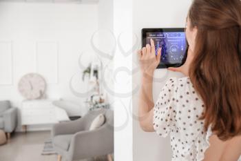 Woman using smart home security system control panel�
