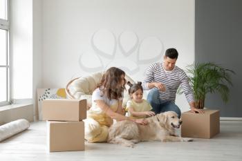 Happy family with dog and moving boxes in their new house�