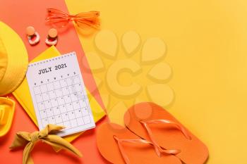 Calendar, notebook and beach accessories on color background�