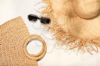 Stylish hat, bag and sunglasses on light background�