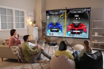 Friends playing video games on big screen at home�