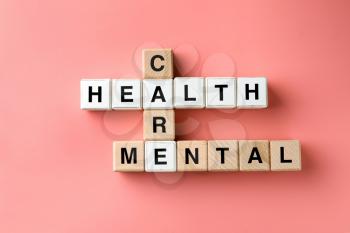 Cubes composed words MENTAL HEALTH CARE on color background�
