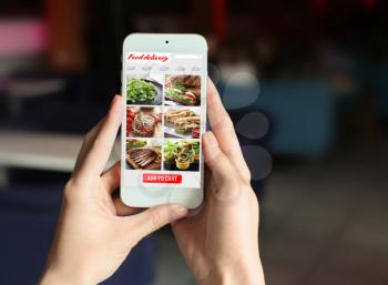 Woman using mobile phone to order food delivery online�