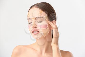 Beautiful woman with reflexology massage areas on her face against white background�