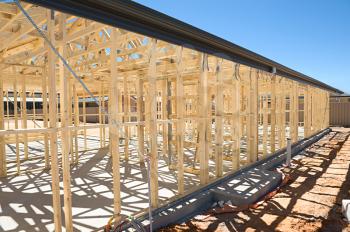 
New residential construction home framing against a blue sky