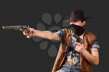cowboy with revolvers in his hands isolated on dramatic background.Shallow DOF