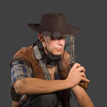 Cowboy with revolver isolated on grey background.Shallow DOF