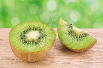 Fresh kiwi fruit on wooden table against natural background 