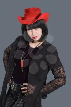 Portrait of pretty woman with red hat on her head isolated on grey