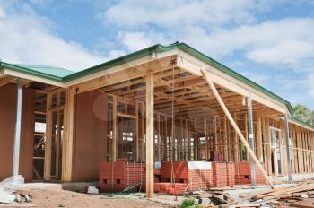 New residential construction home framing against a blue sky