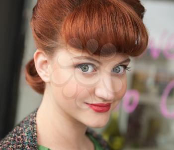Outdoor portrait of young beautiful woman with retro hairstyle and make-up