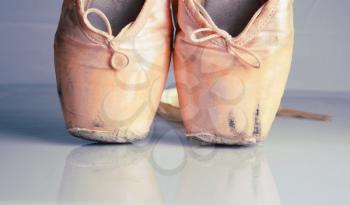 Old used pink ballet pointe shoes with reflection 