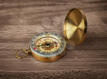 Retro brass compass on a wooden background 