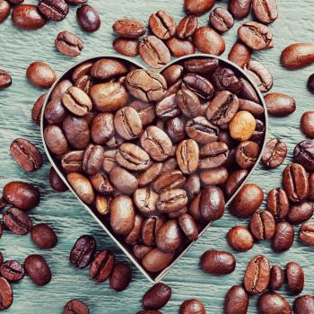 coffee beans as background from good roasted coffee beans with heart shaped metal frame