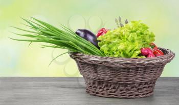 
Fresh organic vegetables in a basket on wooden vintage table