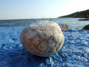 Royalty Free Photo of a Big Stone on a Blue Surface