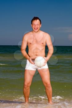 Royalty Free Photo of a Man With a Ball at the Beach