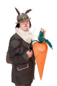 Royalty Free Photo of a Man in a Bunny Suit Holding a Large Carrot