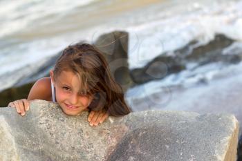Pretty playful little girl on the beach