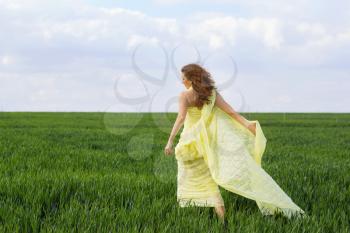 Gorgeous expressive young woman in a green field