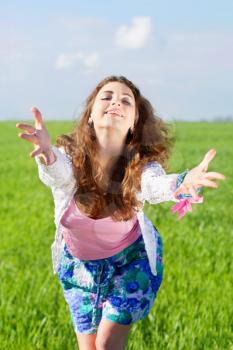 Portrait of cheerful young woman in a green field