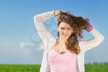 Portrait of joyful charming young woman in a green field 