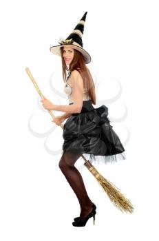 Playful young woman with a besom wearing costume witch