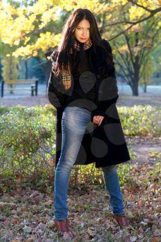 Portrait of a beautiful young brunette in autumn park