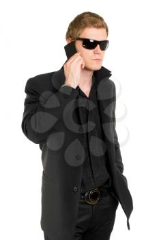 Young man in black sunglasses talking on the mobile phone. Isolated